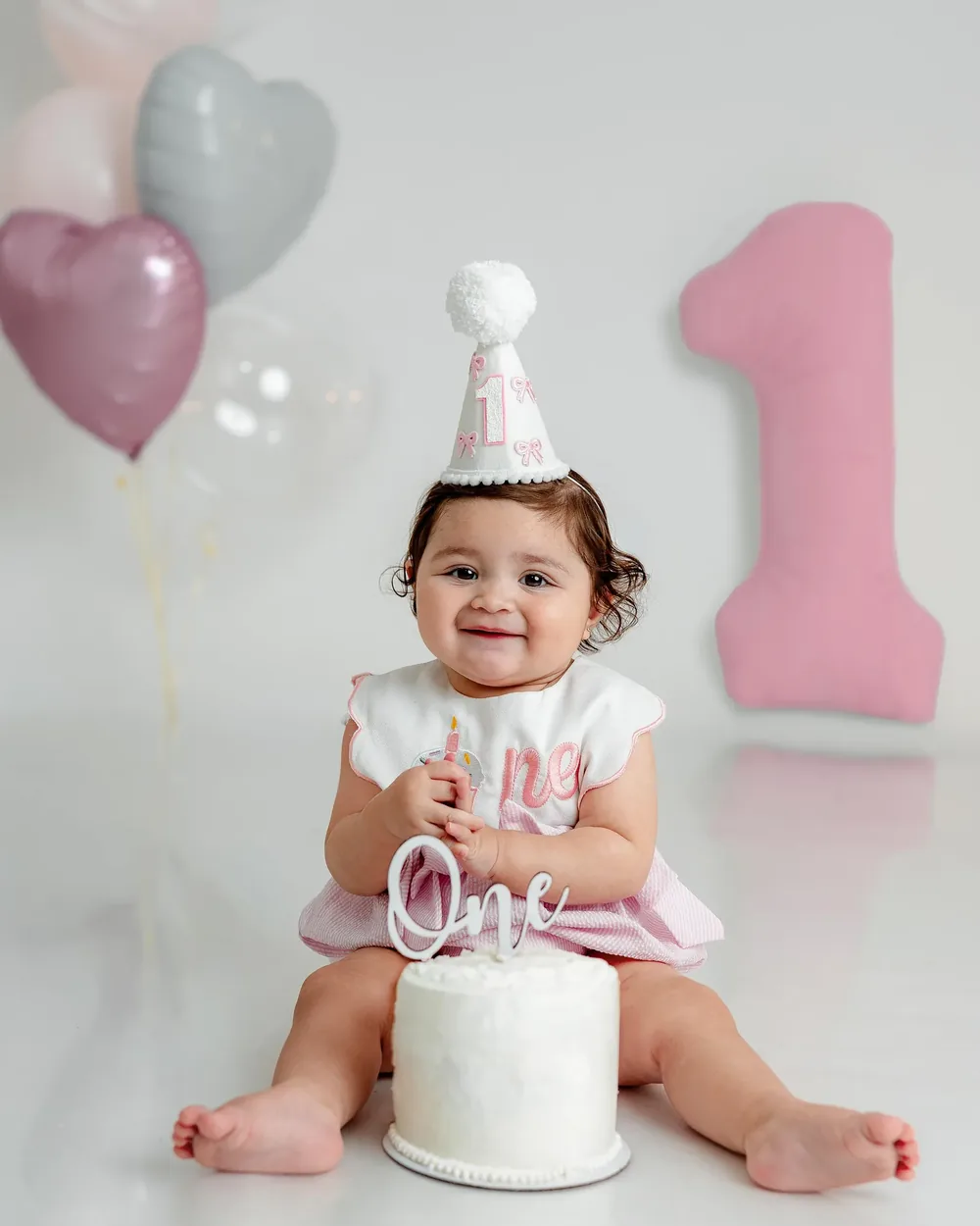Fotografía smash cake — bebé con gorrito de cumpleaños y su pastel de primer año